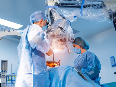 Two doctors in an operating room working on a patient. 