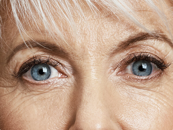 Close-up shot of a woman's face focused on her blue eyes. 