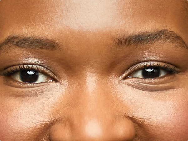 Close-up shot of a woman's face focused on her brown eyes. 