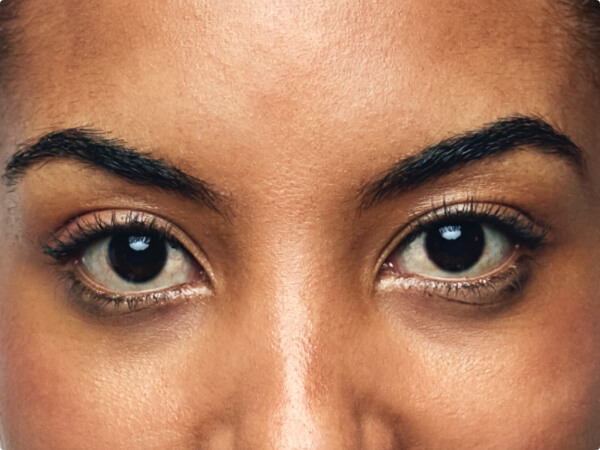 Close-up shot of a woman's face focused on her brown eyes. 