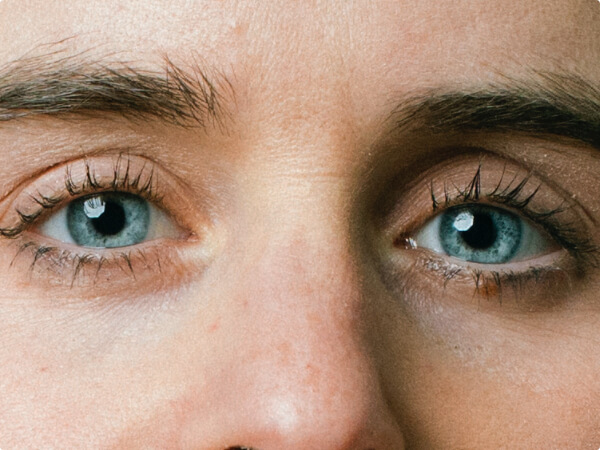 Close-up shot of a woman's face focused on her blue eyes. 