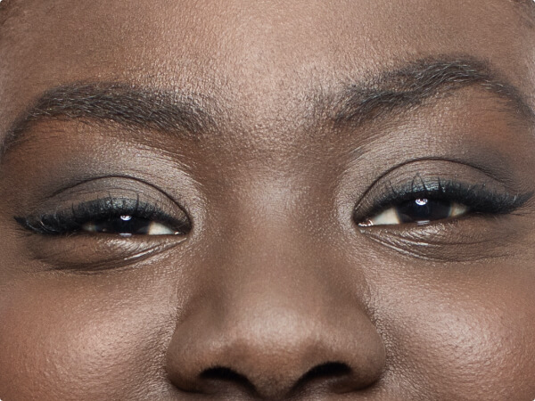 Close-up shot of a woman's face focused on her brown eyes. 