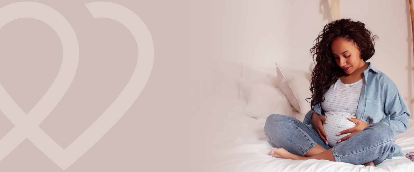 A pregnant woman looking down at her belly.