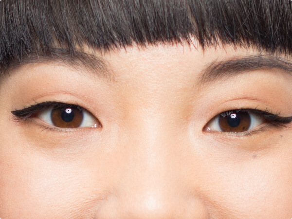 Close-up shot of a woman's face focused on her brown eyes. 