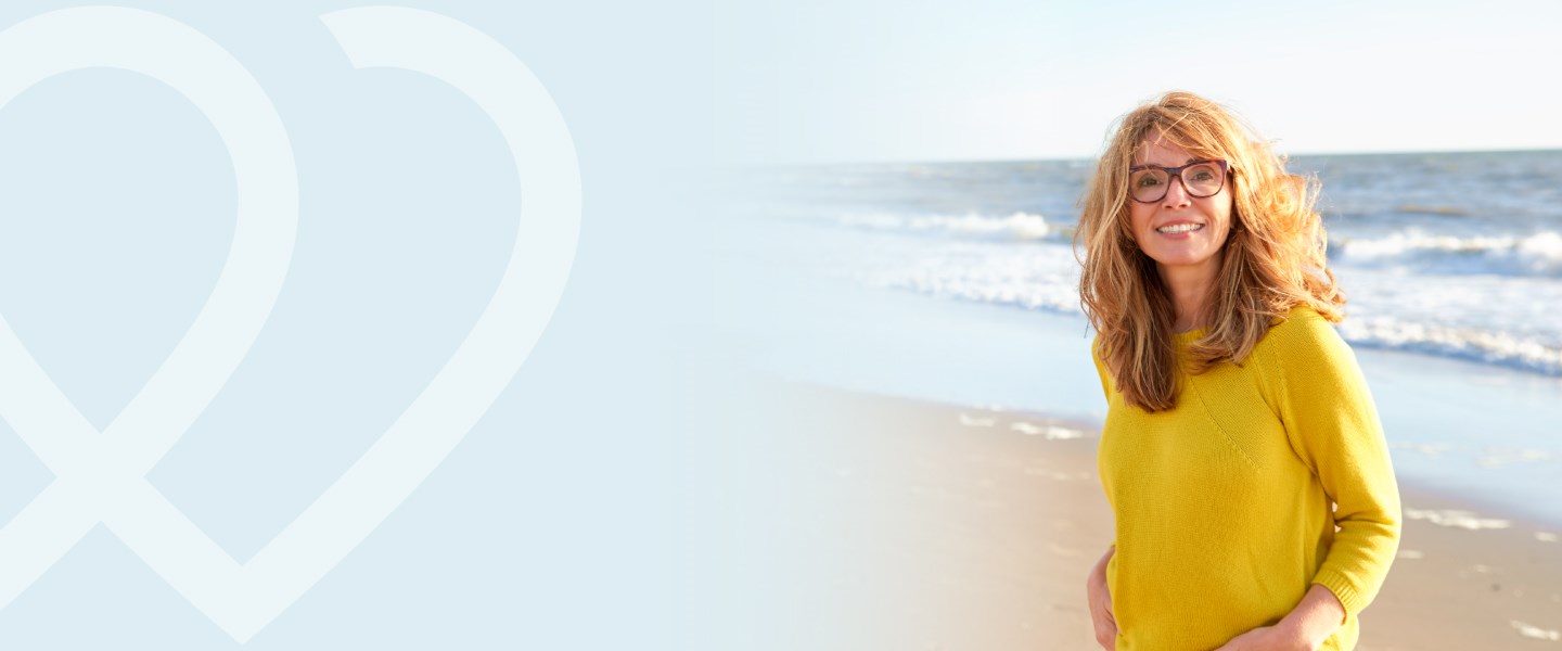 A woman on the beach staring at the camera.
