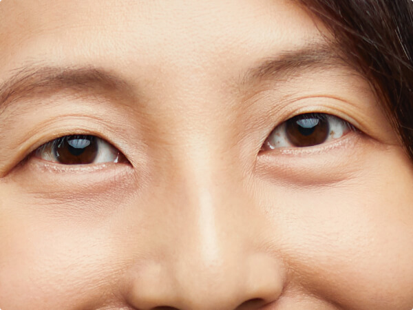 Close-up shot of a woman's face focused on her brown eyes. 