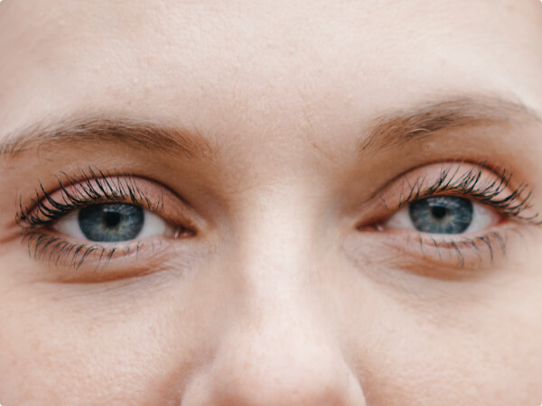 Close-up shot of a woman's face focused on her blue eyes. 