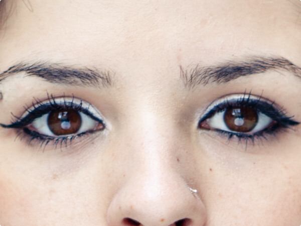 Close-up shot of a woman's face focused on her brown eyes. 