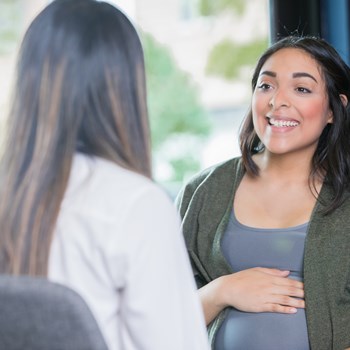 a doctor and pregnant patient talking in an office