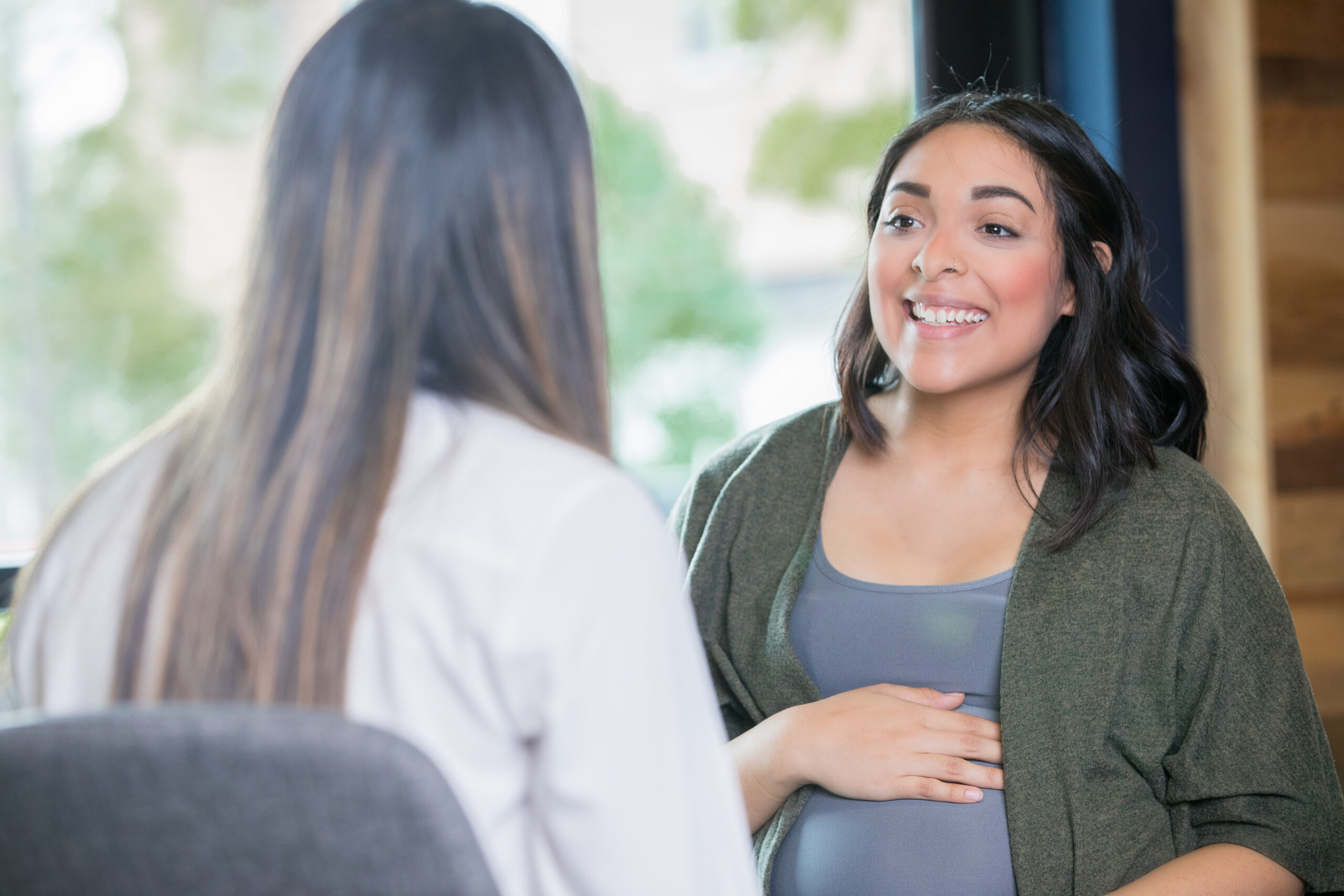 a doctor and pregnant patient talking in an office