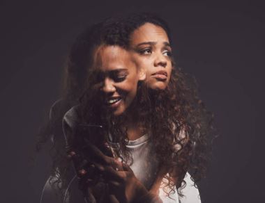 young woman smiling looking down while a her inner self looking up for help