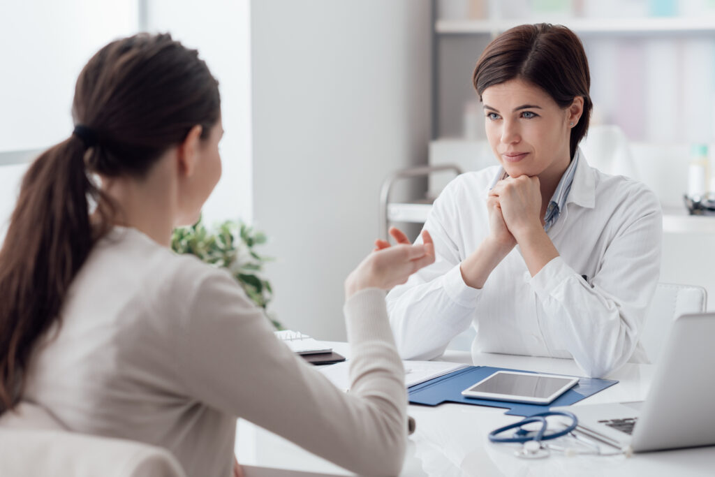 A doctor and patient talking inside an office.