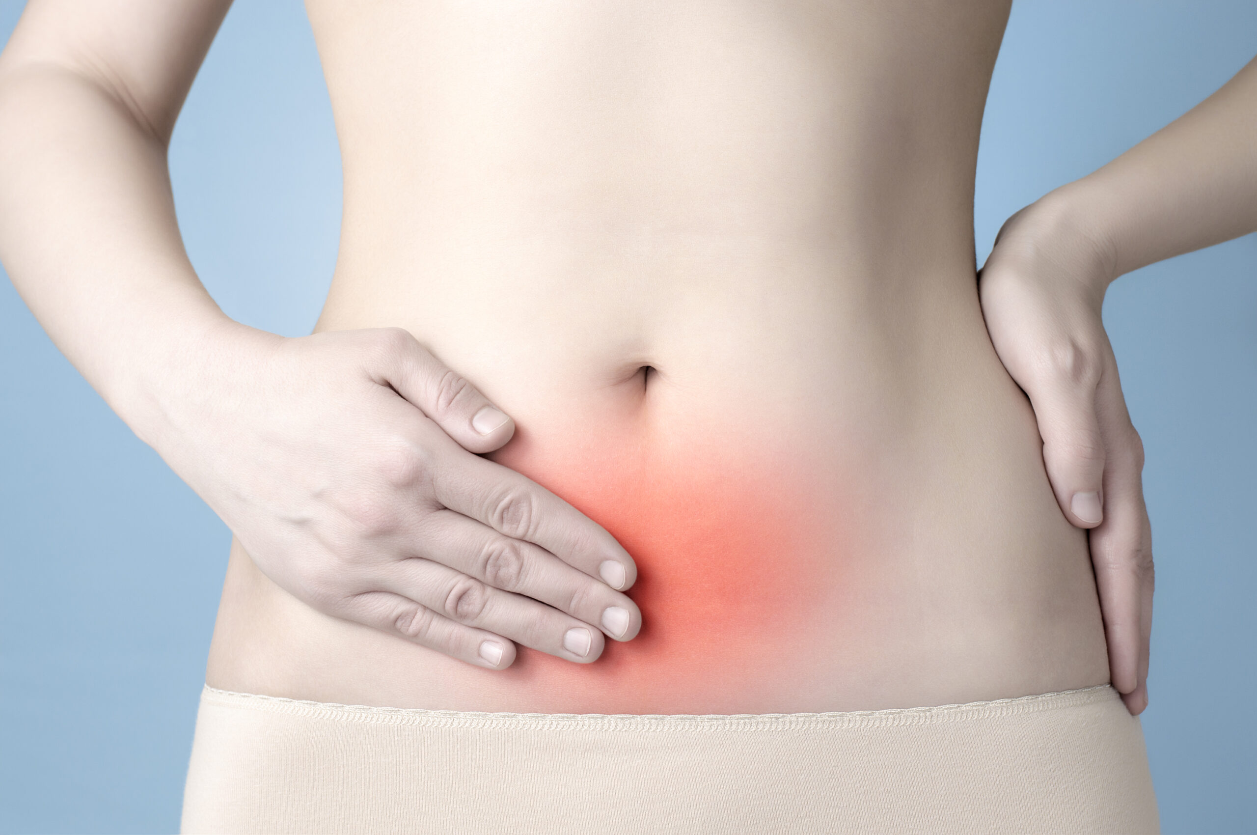 A close-up shot of a woman's belly with red around her pelvis depicting pain.