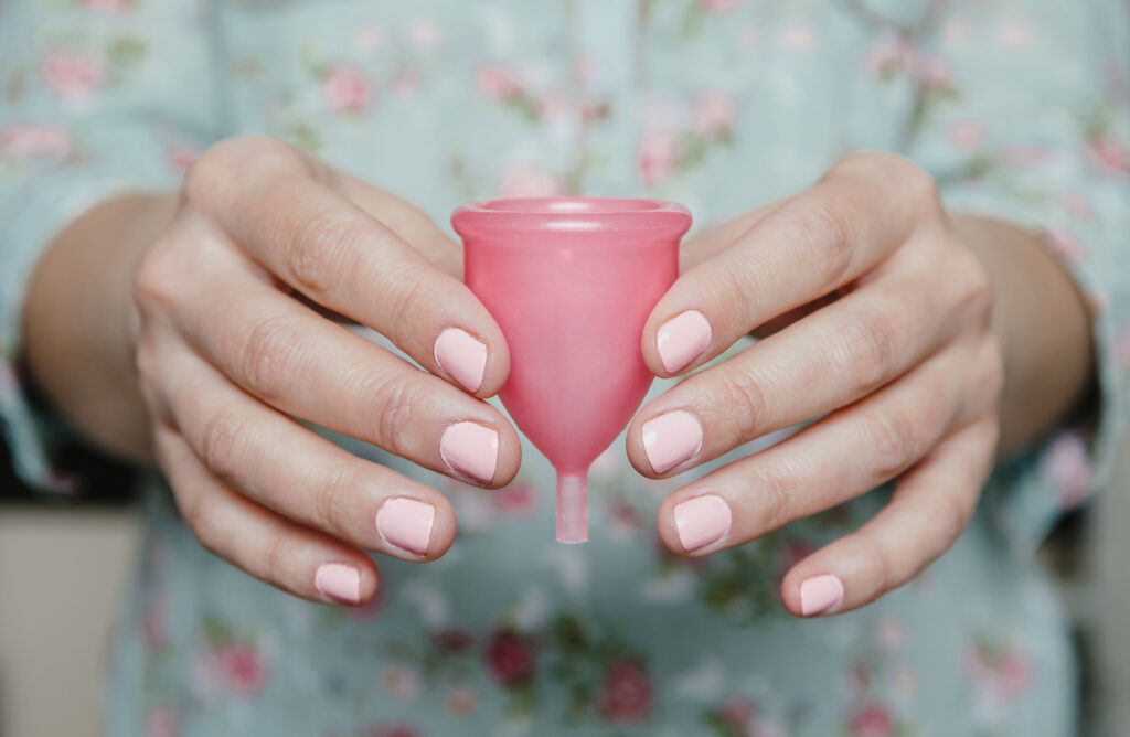 Two hands holding a period cup.