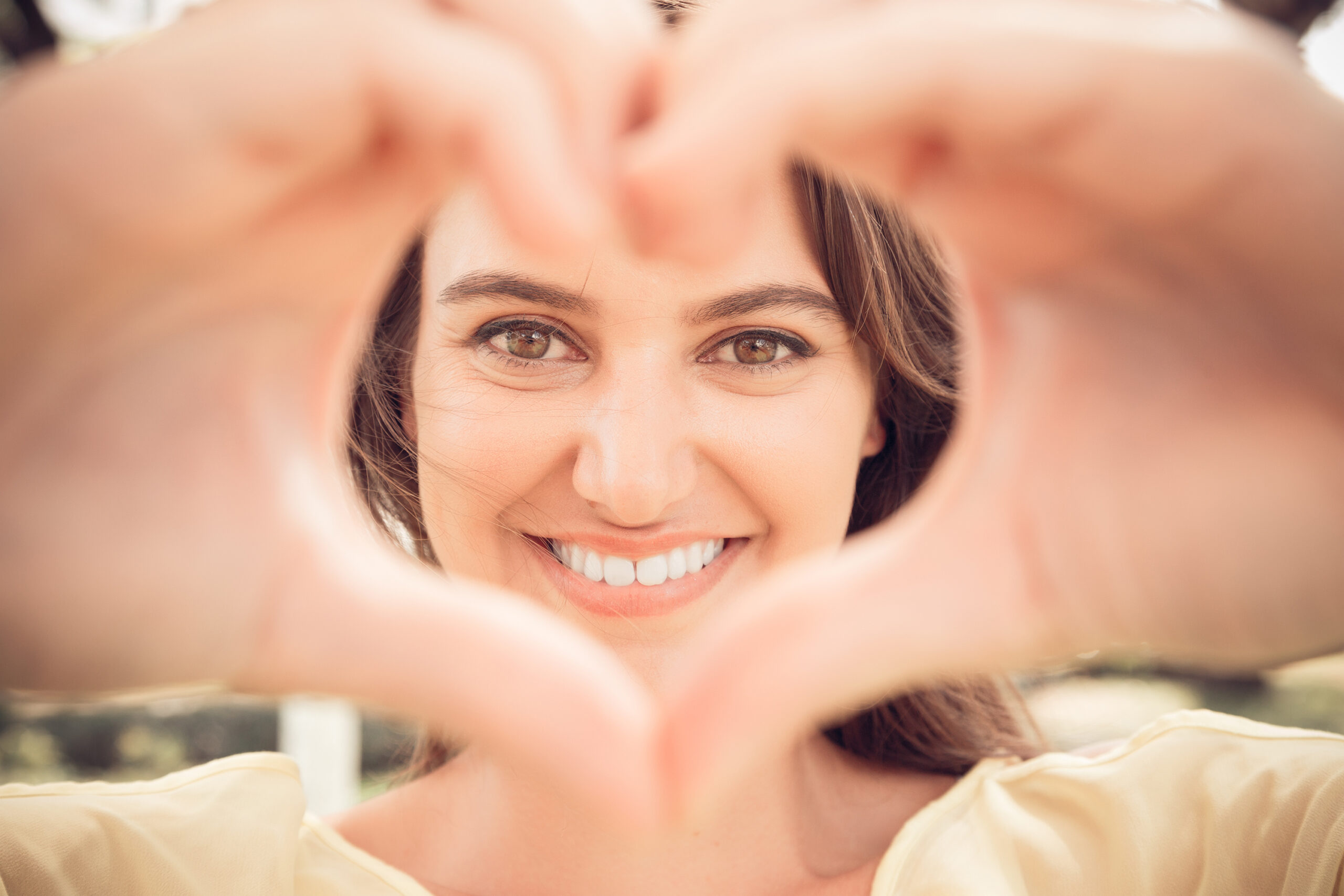 Woman making a heart symbol with her hands.