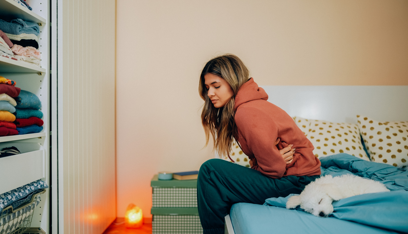 woman with fibroids hunched over in pain