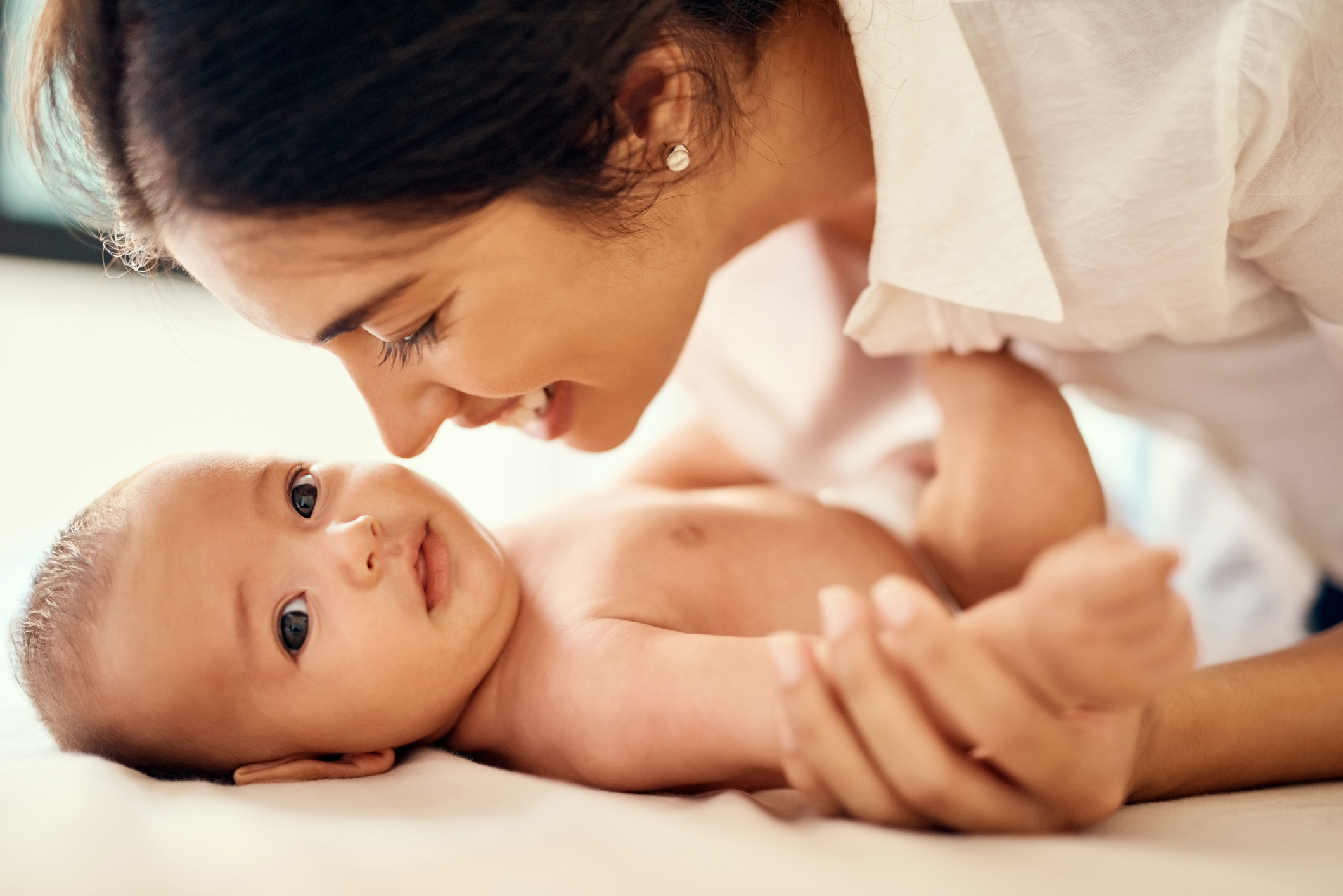 A mother with her face very close to her baby's face.