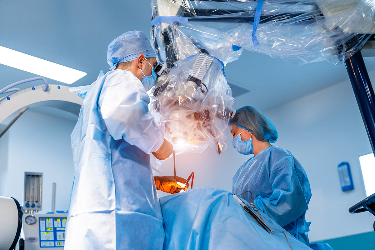 Two doctors in an operating room working on a patient.